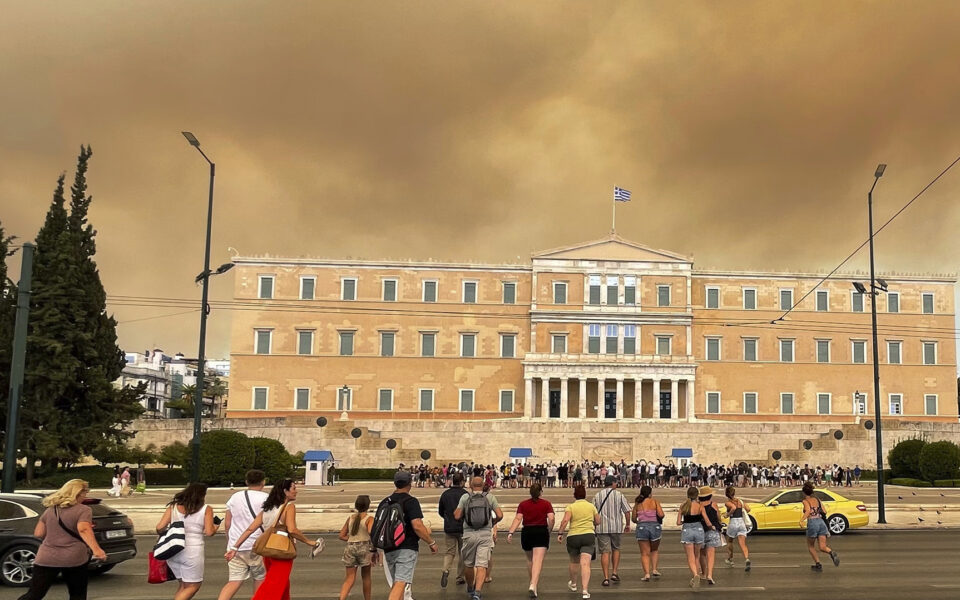 A wildfire near Greece’s capital darkens the skies over Athens and advances fast